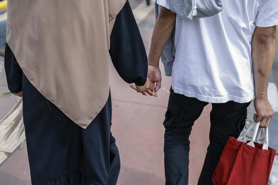 Indonesia castiga ahora con prisión el sexo extramarital y la difusión de noticias falsas | 3 | Una pareja camina de la mano por una acera en Yakarta